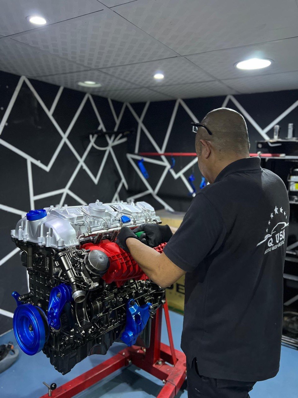 Technician assembling a rebuilt engine on a stand
